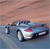 Pixelated image of a blue and white car with red accents on a gradient background transitioning from brown to blue.