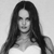 Black-and-white pixelated image of a person with long dark hair, neutral expression, and light-colored top against plain background.