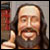 Pixelated image of a person with long dark hair and beard giving a thumbs-up gesture, holding an object in the background.