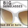 Static image of white-framed sunglasses with brown-tinted lenses, text "BIG SUNGLASSES" above and "had me at hello" below.