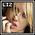 Pixelated close-up of a person's face with visible eyes, nose, and mouth; white text 'LIZ' in top-left corner on dark background.