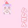 Pixelated hamster character with Santa hat and wreath, pink background with yellow sparkles, vertical Japanese text in red and green outlines.
