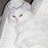 Pixelated close-up of a white cat's face with green eyes and pink nose, set against light background.