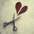 Scissors cut two dark red hearts from a light beige background, with colorful striped borders surrounding white heart shapes.