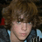 A pixelated image of a person with brown curly hair on the left, next to vertical and horizontal arrangements of pink '<3' symbols and text 'heart' and 'you' on a blue background.