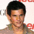 A person with dark hair appears in five distinct poses across a , each showing different clothing and background elements