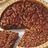 A pixelated image of a chocolate pie with slices removed, accompanied by cyan text on a dark red background.