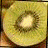 Four fruit slices arranged in a : kiwi, orange slice with green peel, strawberry with white flower, and lemon slice