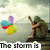 A pixelated image of a hooded figure sitting on a rock by water, with colorful balloons and changing text overlays.