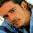 A pixelated close-up of a person's face in a blue shirt, with visible mouth and ear details.