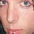 Close-up of a person's face showing eyes, nose, and mouth with light skin tone and pink lips, cropped tightly around facial features.
