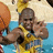 Pixelated image of a person in yellow and blue attire holding an orange object against a light background with blue water-like area.