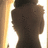 Pixelated image of a person's back with dark hair, wearing a dark top, against a bright background with vertical light streaks.