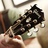 Pixelated close-up of a dark-colored guitar headstock with visible tuning pegs and a light-colored body section, set against a blurred background.