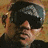 Two side-by-side pixelated images of a person wearing dark clothing and a blue cap, with one image showing the face turned left and the other facing forward.