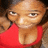 Pixelated close-up of a person wearing red clothing with visible chest area, brown hair, and neutral expression against blurred background.