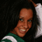 A pixelated image shows a person with dark curly hair wearing a green and white striped shirt, next to a blue background with red '<3' text.