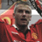 Pixelated static image of a person in red sports attire with visible facial features and partial background elements.