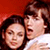Static 50x50 pixel icon showing two people in close proximity with a red background, rendered at low resolution with visible dithering and color blending.