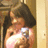 Pixelated image of a person with dark hair holding a bright light source against a warm-toned background.