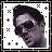 Pixelated grayscale portrait of a person with dark hair, framed by black and white border elements including plus signs and squares.