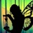 Pixelated figure in dark clothing with light-colored hands raised near face against green and yellow striped background.
