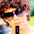 A pixelated image of a person with brown curly hair and sunglasses, showing three variations of text overlays.