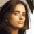 Pixelated close-up of a person with shoulder-length brown hair, light skin tone, and neutral expression against a light background.