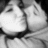 A grayscale pixelated image of a person's face with closed eyes and visible facial features including nose, mouth, and hair.