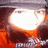 A pixelated static image shows a bright white oval shape surrounded by dark brown and orange hues, with no visible text or distinct subjects.