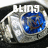 A silver metallic object with a blue circular center and white text above it, displayed in three views showing slight variations.