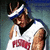 Pixelated image of a person wearing a white sleeveless shirt with red text and blue headband, next to bold red text on blue background.