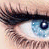A close-up of a human eye with blue irises and long dark eyelashes, showing subtle variations in the iris pattern across four