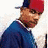 A pixelated image of a person wearing a red cap and blue jacket with yellow circular icons below text reading 'Grillz' on a blue background.