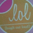A circular icon with a purple and brown gradient background featuring the text 'lol' in white cursive script, surrounded by pixelated black text variations of 'lol' on a white backdrop.