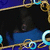 A static pixelated image shows a dark central area framed by ornate golden borders with blue and cyan accents, set against a dark blue background.