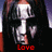 A pixelated image of a person with long dark hair and a white mask-like face, with red text below the face changing across frames.