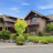 Pixelated static image of a house with a sloped roof, surrounded by greenery under a blue sky.