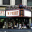 Static image of a building facade with a prominent sign displaying 'Globe Theatre' text above a darkened entrance area.