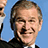 A pixelated image of a man with short graying hair and a mustache, wearing a dark suit jacket over a white shirt against a light blue background.