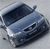 Pixelated blue vehicle with dark interior and visible headlights on light gray background.