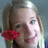 A pixelated static image shows a person with light hair holding a red flower near their face against a muted blue background.