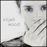 A grayscale portrait of a person with blue eyes covering their mouth, featuring the text 'elijah wood' in pixelated font on the left side.