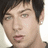 Pixelated portrait of a person with short dark hair against light background, adjacent to black with pink text