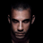 Pixelated static image of a human face with dark hair and neutral expression on black background, rendered in low-resolution 256x256 pixels.