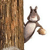 Pixelated squirrel clinging to tree trunk, holding acorn, brown and white fur, white background, static image.