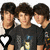 Three identical figures with dark hair and black shirts stand side-by-side, each wearing a white collar and holding a large heart-shaped object.