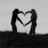 Two silhouetted figures form a heart shape with their arms against a light background, while the right side displays text over a beach scene.