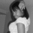 Black-and-white pixelated image of a person with long dark hair wearing a light-colored top, viewed from the side against a plain background.