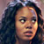 Pixelated static image of a person with dark curly hair and light skin tone, cropped to show upper face and shoulders against a gradient background.